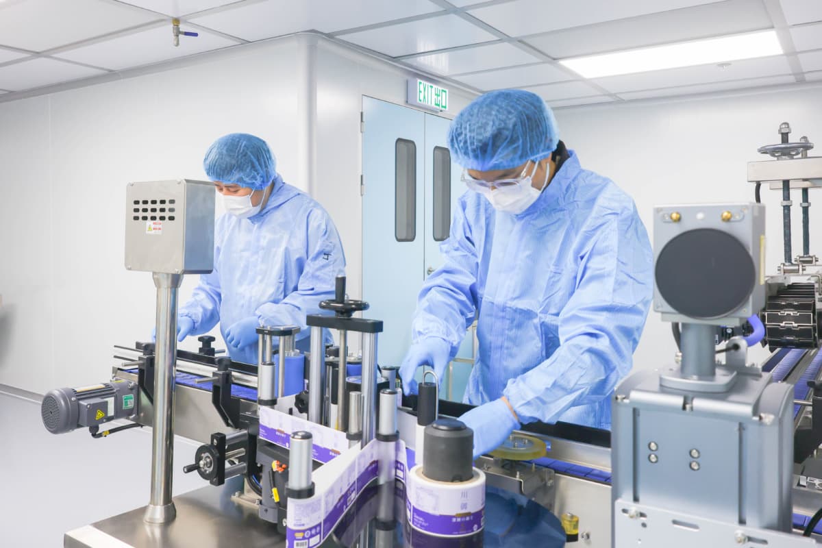 身穿防护衣的生产人员在生产线上处理川御 TY Science 瓶装产品